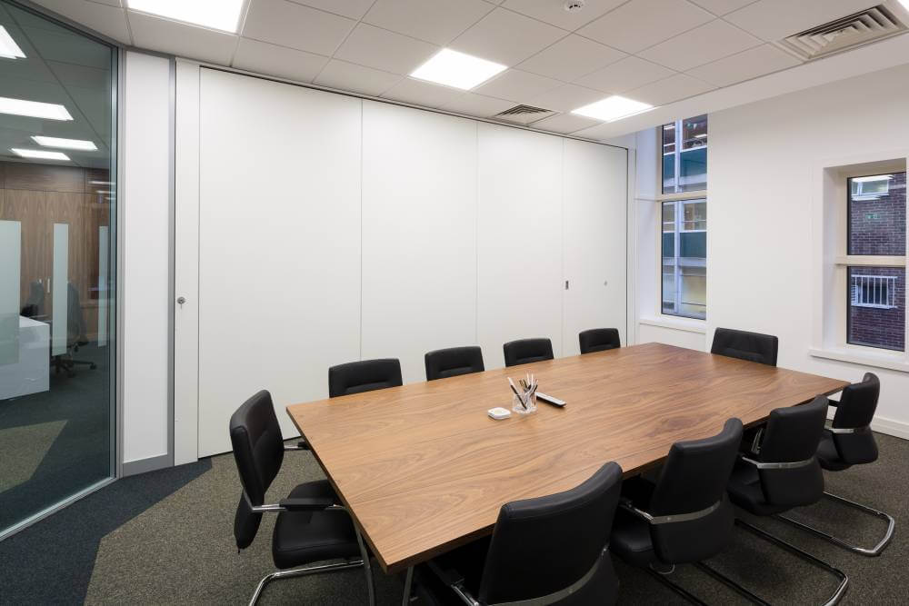 single meeting room with table and cupboard storage space behind