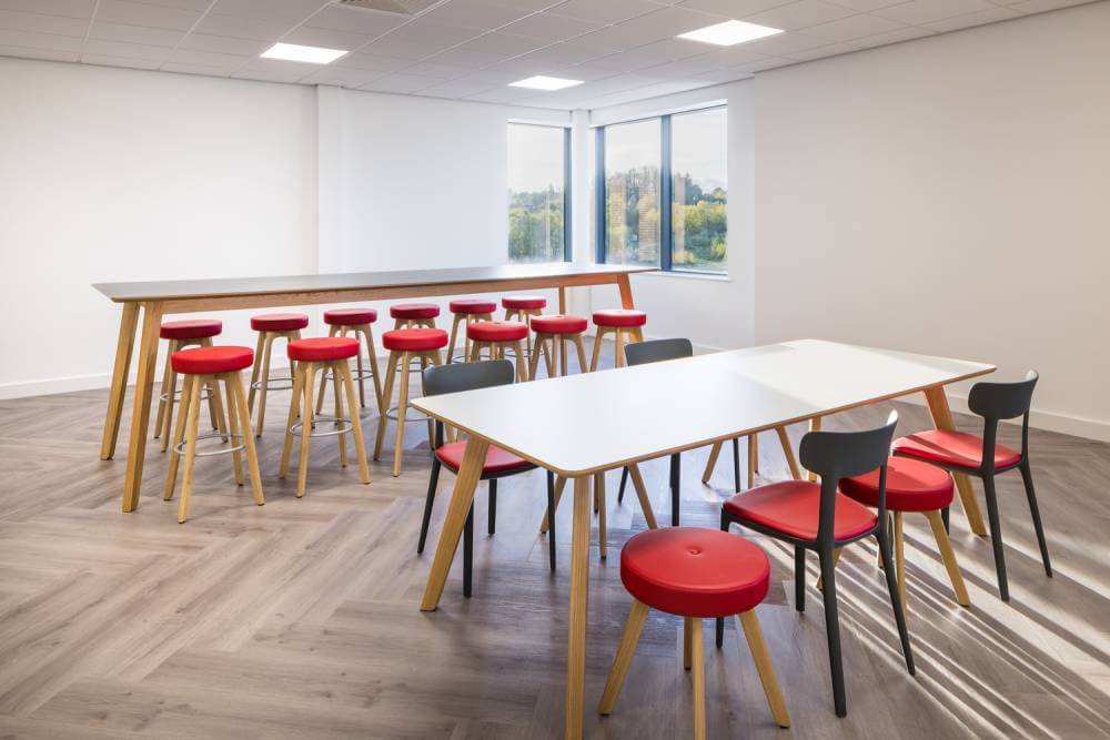 Two office tables with red seating