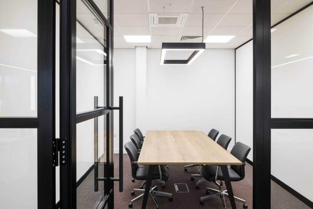 Office partitioning with the door open, leading to a meeting room