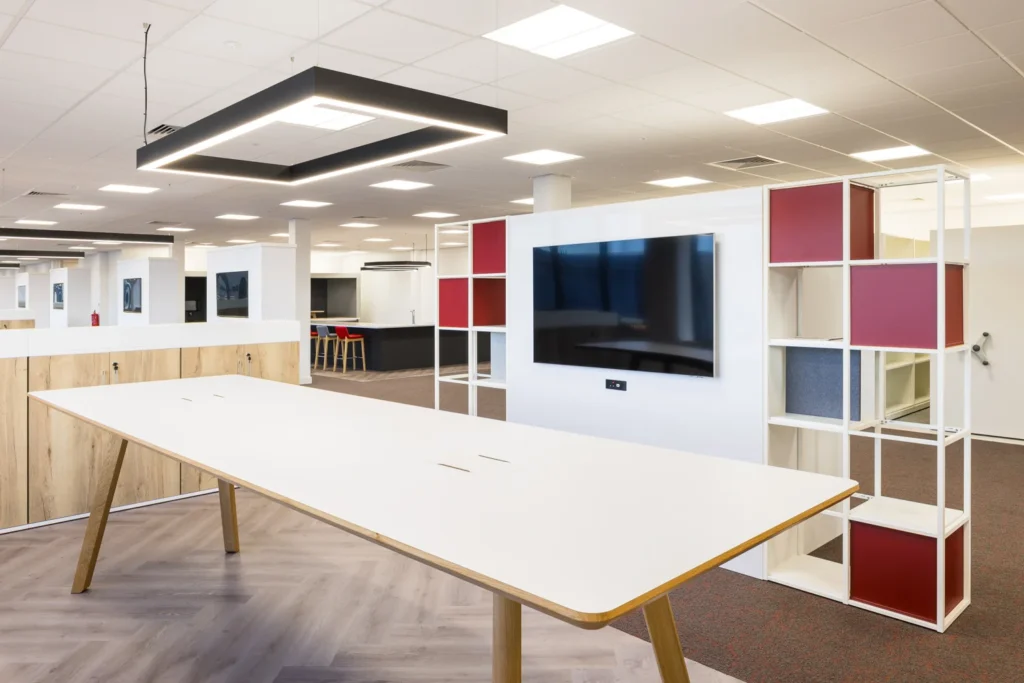 A contemporary meeting space in a modern office with a TV on a room divider